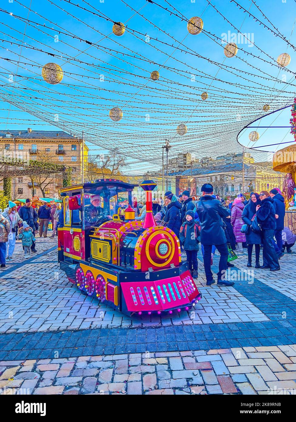 KIEV, UCRANIA - 2 DE ENERO de 2022: El tren turístico, a caballo en la Plaza Sophia frente al árbol de Navidad decorado e iluminado, el 2 de enero en Foto de stock
