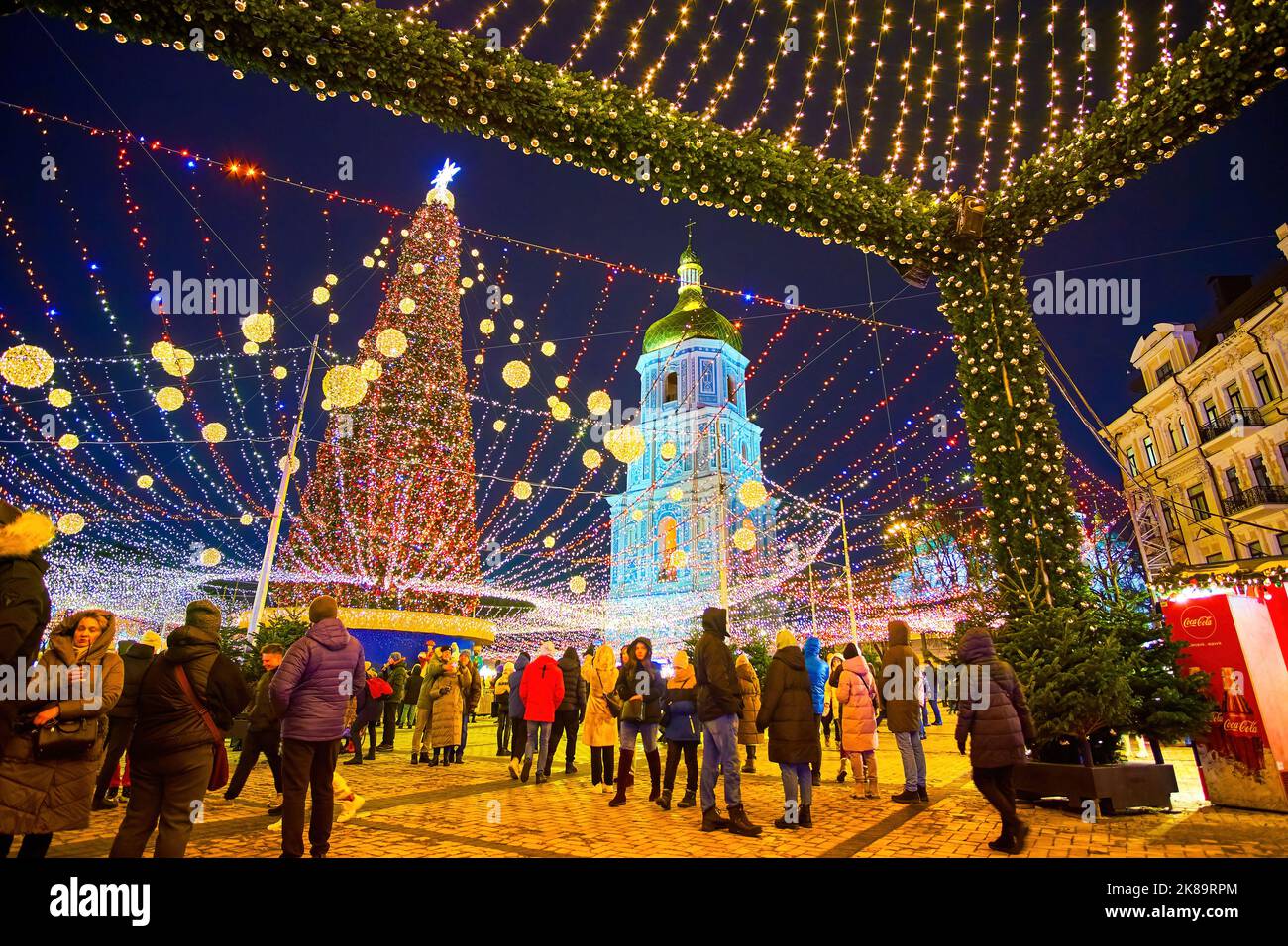 KIEV, UCRANIA - 28 DE DICIEMBRE de 2021: Noche en la Plaza de Sofía con una vista sobre la puerta decorativa de la Feria de Navidad con alto y ricamente decorado principal C Foto de stock