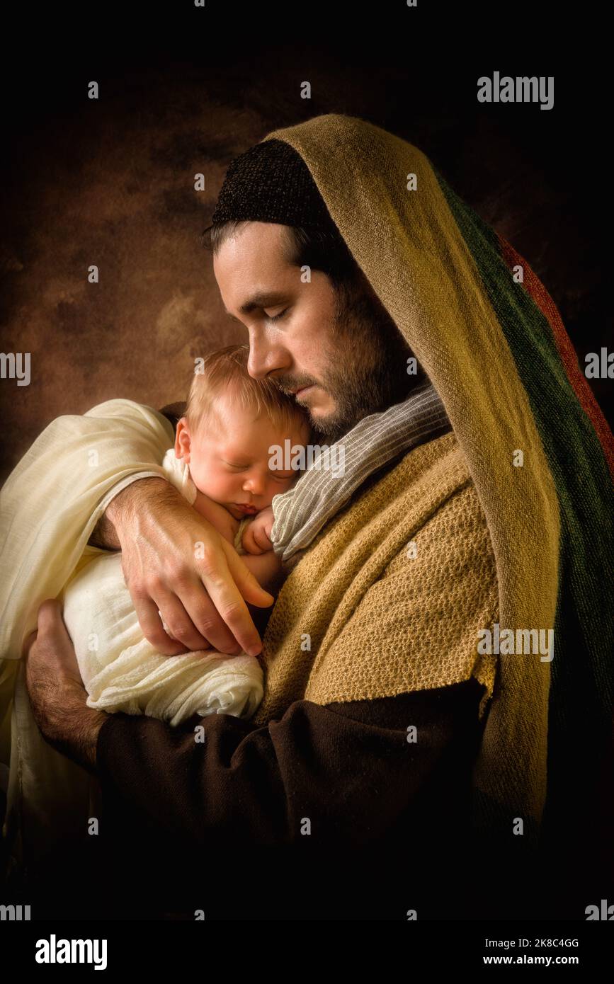 Orgulloso papá jugando al Padre Joseph con su propio hijo de 8 días en una escena de Navidad Foto de stock