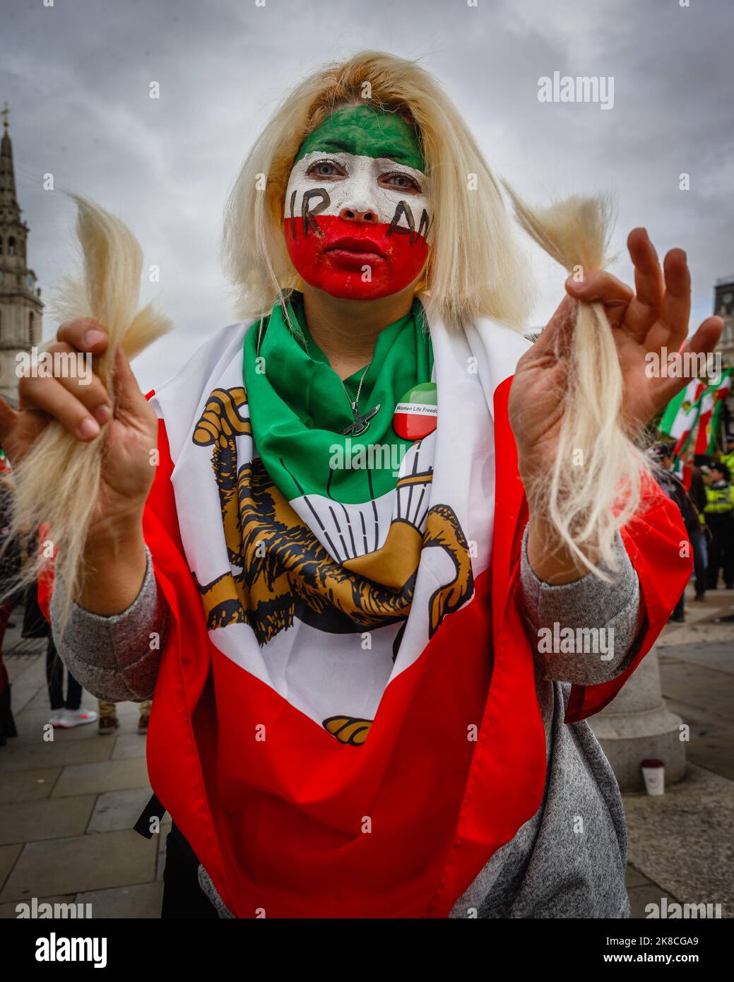 Una manifestante se corta el pelo en la protesta “Mujer, Vida, Libertad” en Londres en apoyo a las mujeres iraníes oprimidas. Foto de stock