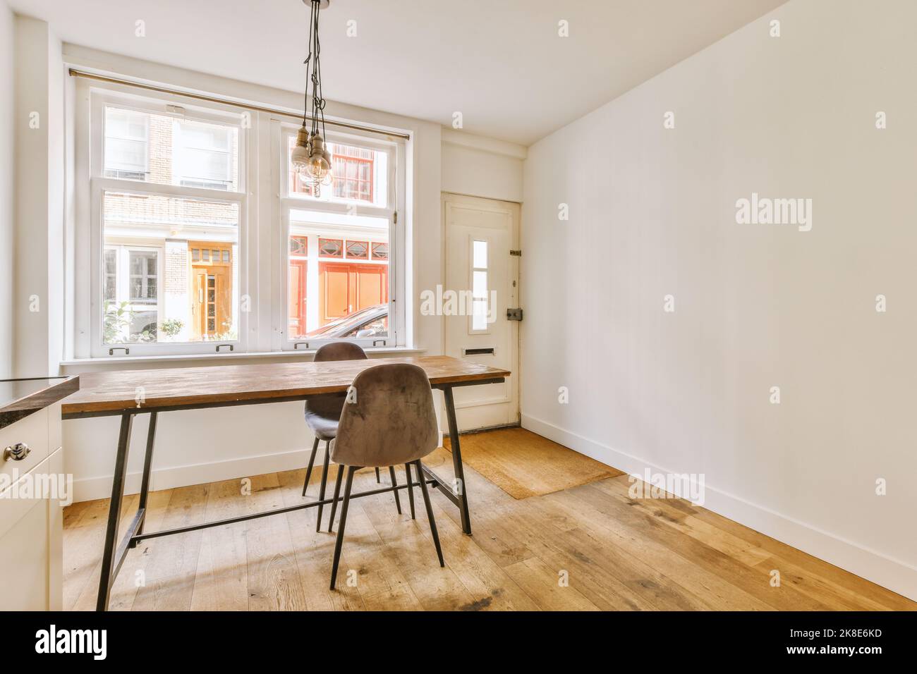 Una hermosa cocina con un diseño en blanco y mármol, un piso de mármol, una  puerta de horno abierta y un estante extraíble.