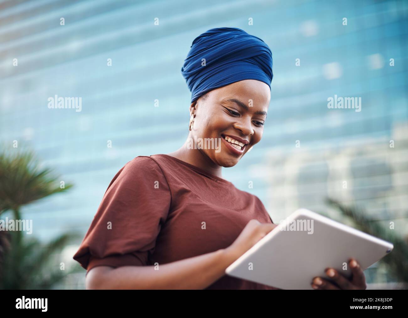 Persigue tu pasión con un propósito. Una joven empresaria que utiliza una tableta digital sobre un fondo urbano. Foto de stock