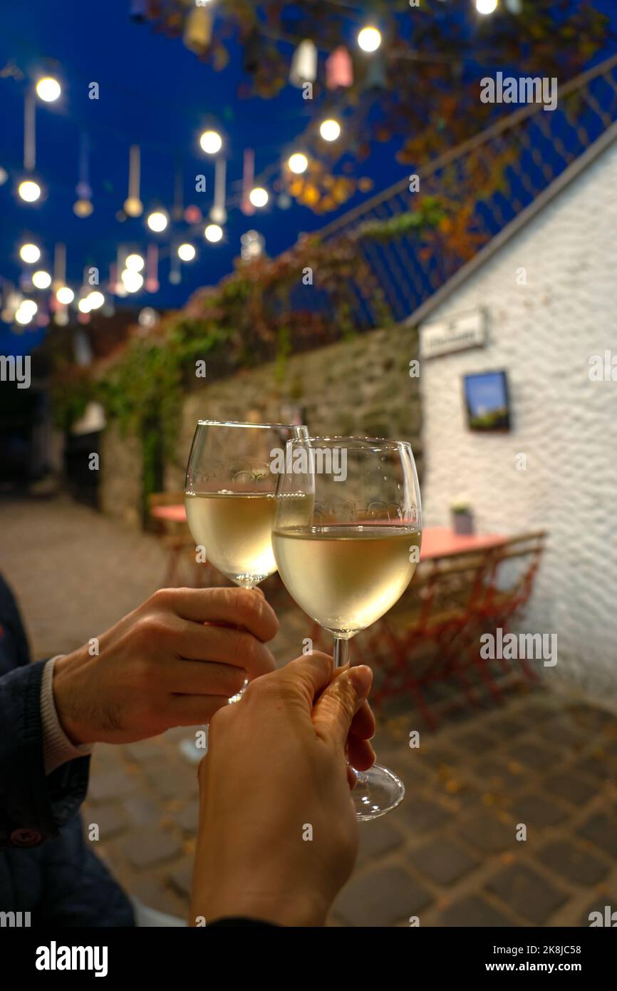 Pareja bebiendo vino blanco en un restaurante en una romántica calle con luces en Szentendre Hungría Foto de stock