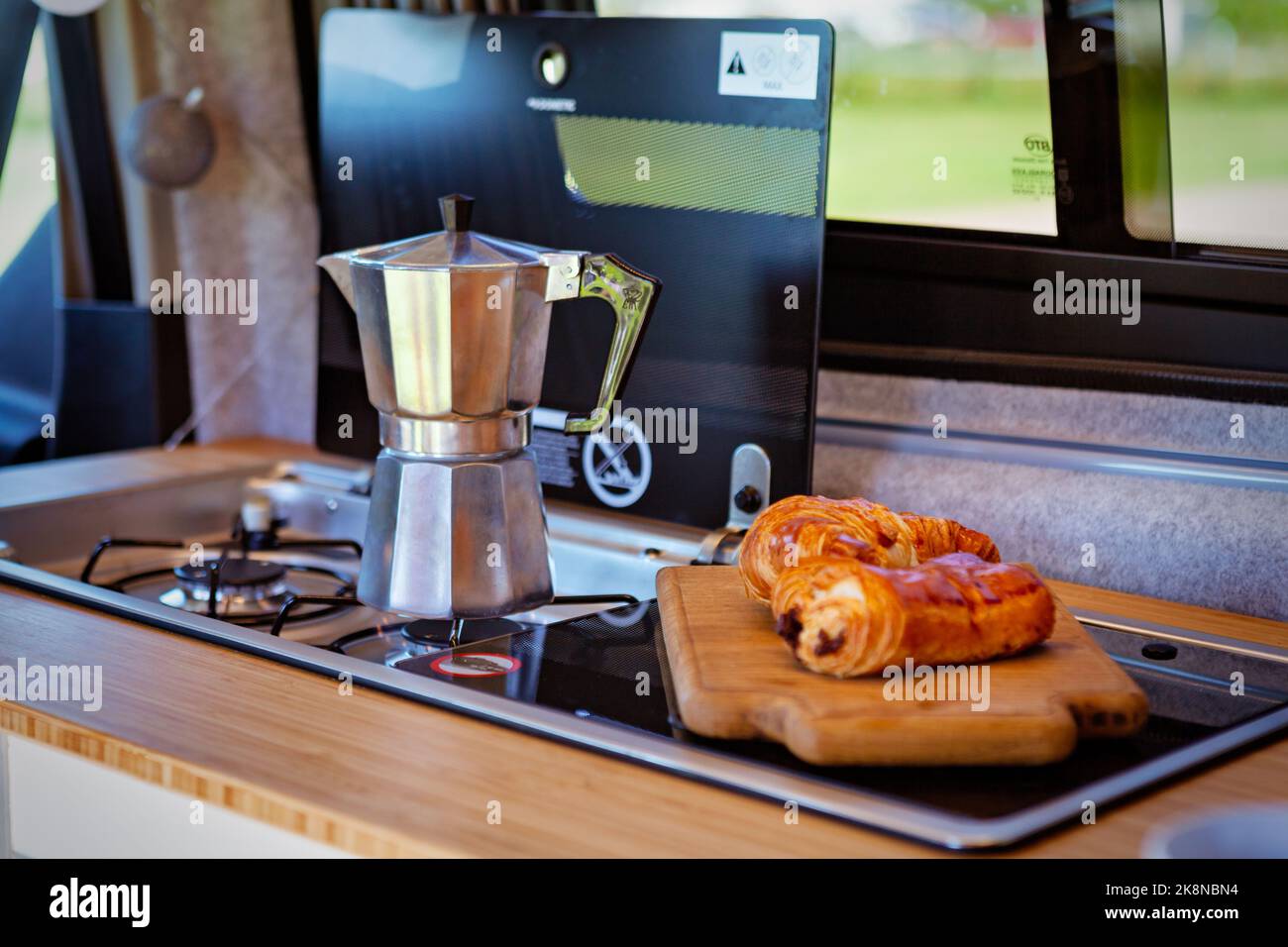 Cafetera Aqua bialetti y pasteles en una furgoneta camper Foto de stock