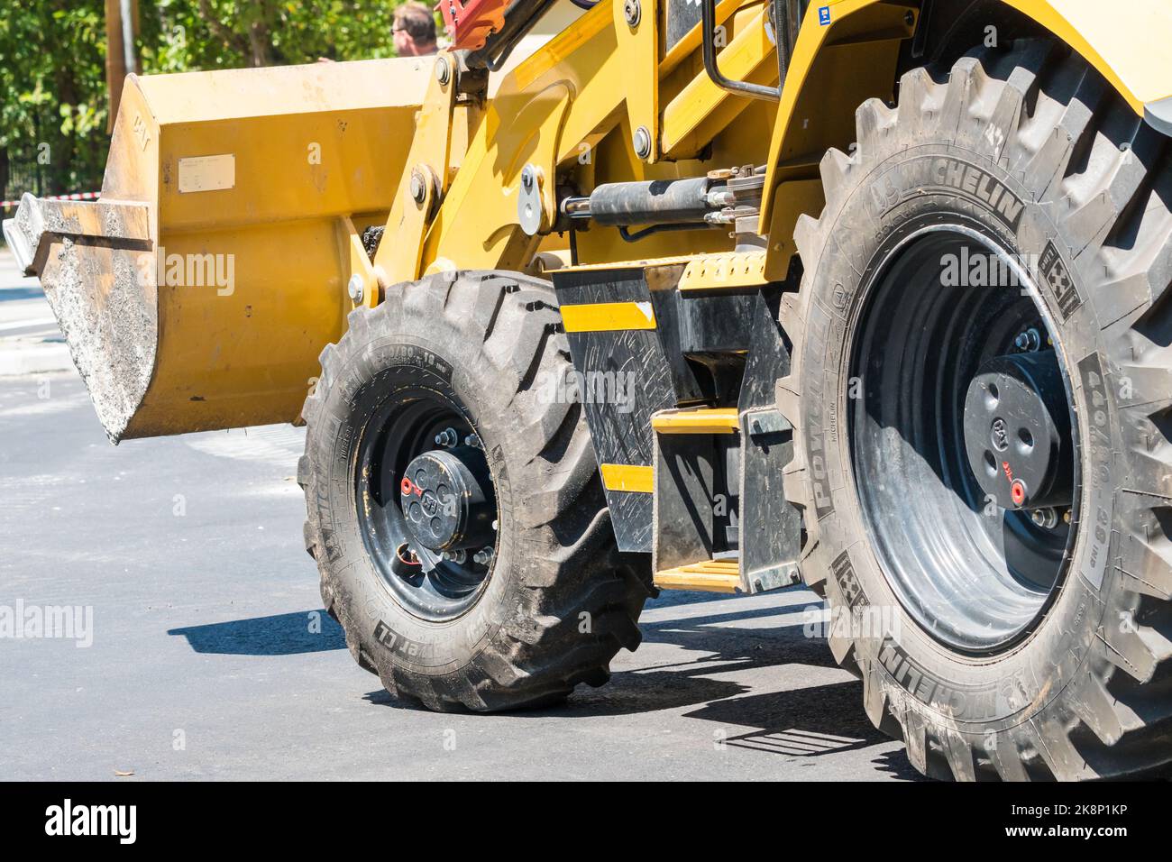 Neumáticos Michelin de servicio pesado o neumáticos en una cargadora excavadora CAT en el concepto de transporte de construcción industrial de carretera Foto de stock