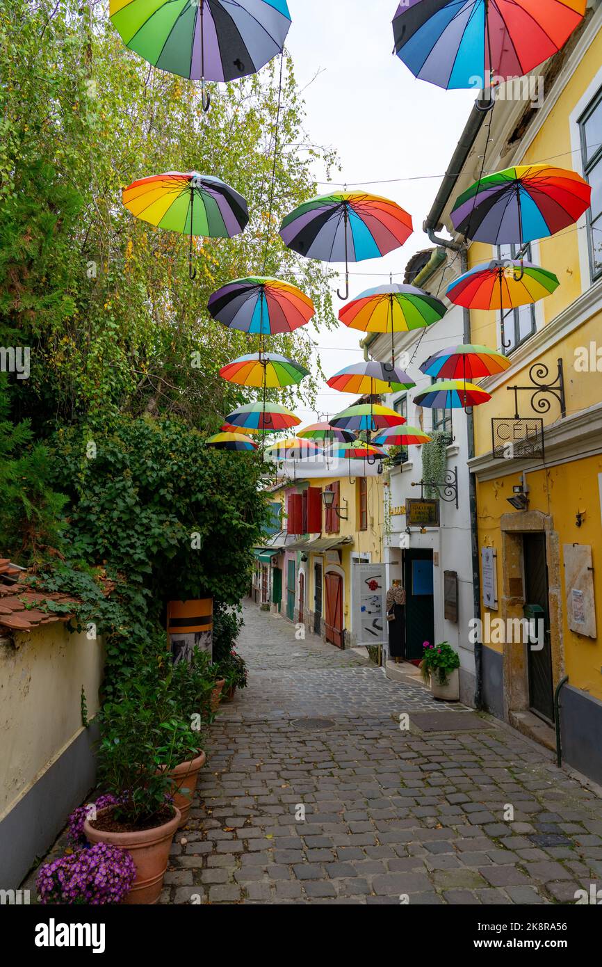 10.14.2022 - Szentendre, Hungría: Coloridas sombrillas colgando sobre la calle en Szentendre con flores . Foto de stock