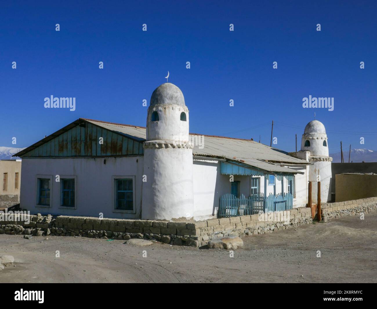 Vista por la mañana del paisaje de la luminosa mezquita sunita blanca en el pueblo de Karakul, Murghab, Gorno-Badakshan, Tayikistán Pamir Foto de stock