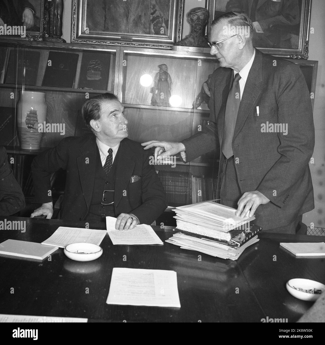 Oslo 1956 Negociaciones salariales La secretaría de LO discute la situación. Jens Berg (TH), Gerente de Oficina, ha preparado bien los documentos. El presidente DE LO, Konrad Nordahl, dirige la reunión. El gran acuerdo económico de esta primavera se acerca a pasos rápidos. Tanto los salarios como los precios, así como todo el desarrollo económico, entran en escena. La revisión arancelaria incluye a casi 300.000 trabajadores. Sin embargo, no es posible formular requisitos salariales. En primer lugar, hay que saber más sobre la evolución de los precios en general, los precios agrícolas y más. Photo Aage Storløkken / Actual / NTB Foto de stock