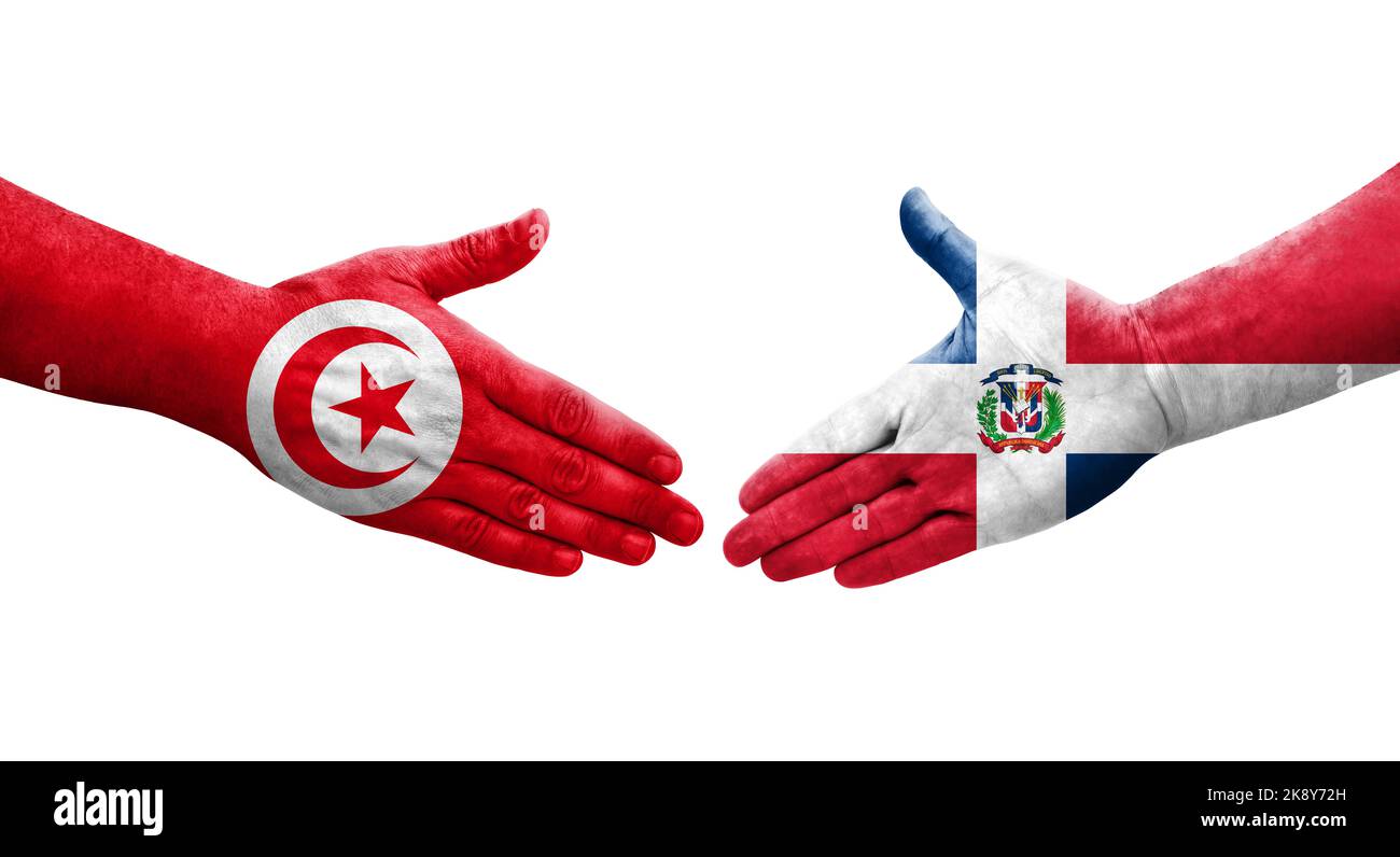 Apretón de manos entre la República Dominicana y Túnez banderas pintadas en las manos, imagen aislada y transparente. Foto de stock