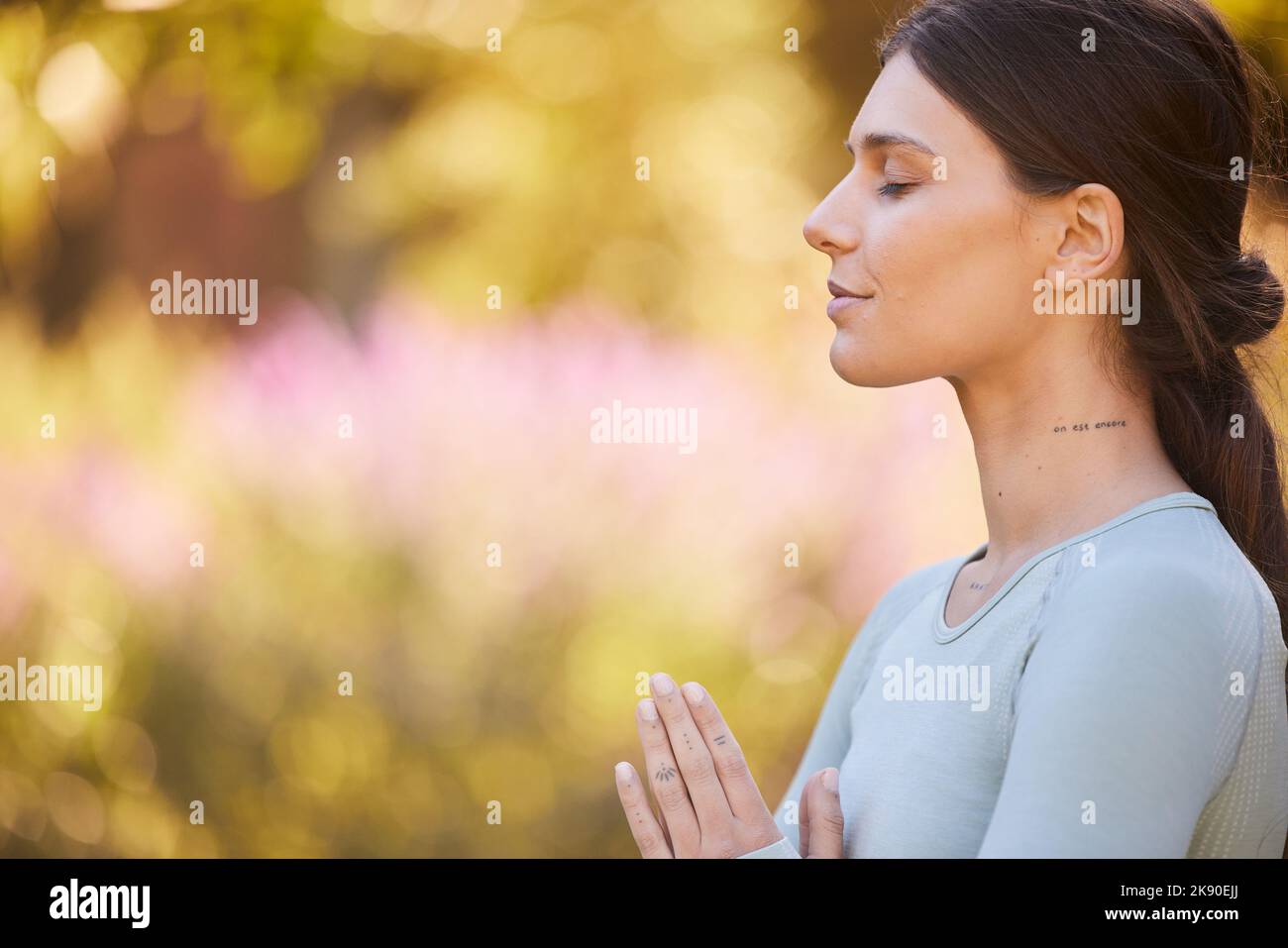 Calma, meditación y mujer haciendo yoga en el parque para la paz, tranquilidad y zen. Estilo de vida saludable, relax y manos de la niña juntas para mediar en la naturaleza Foto de stock