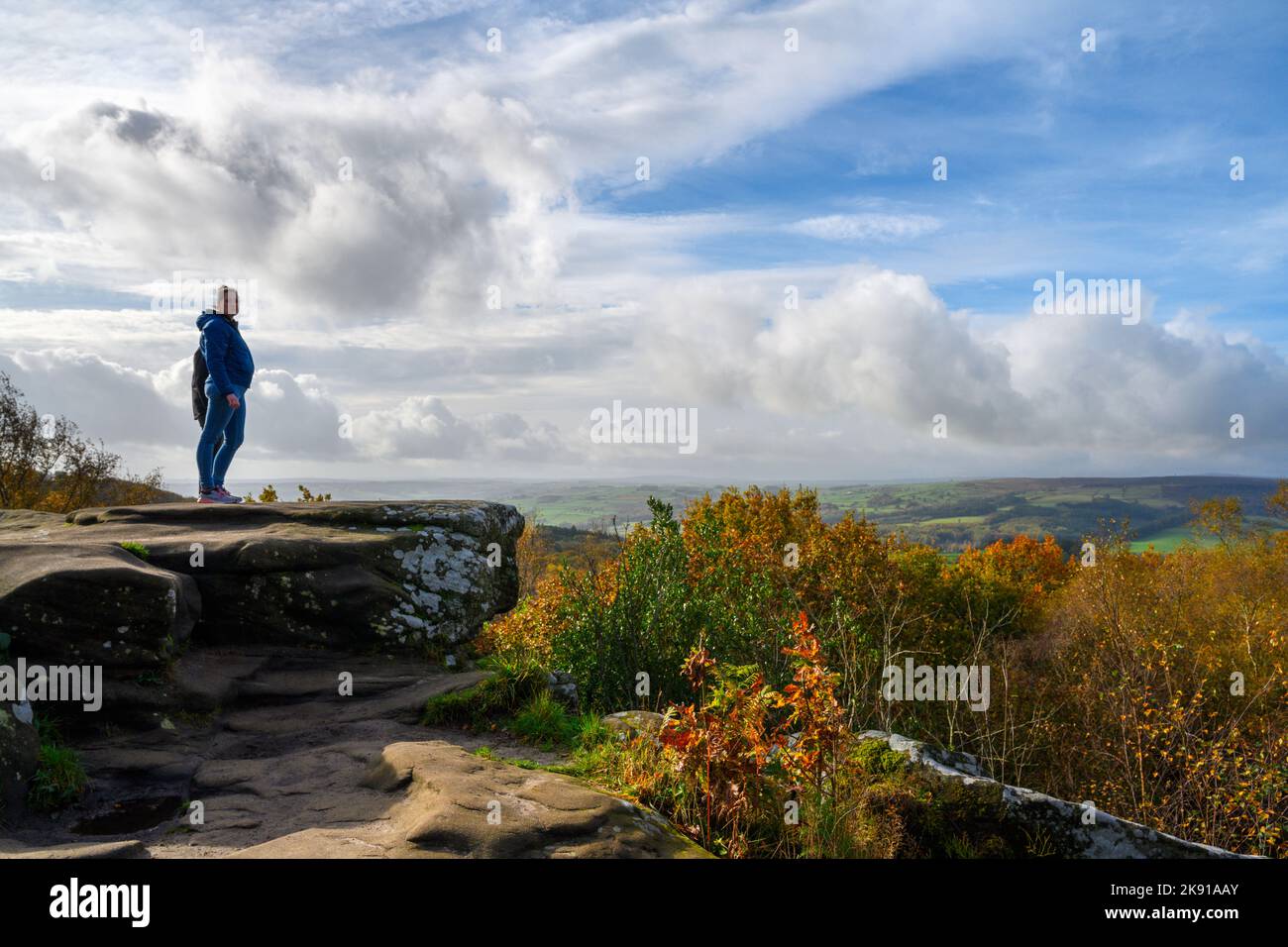 Pareja de pie sobre una roca en Brimham Rocks, cerca de Harrogate, North Yorkshire, Inglaterra, Reino Unido Foto de stock