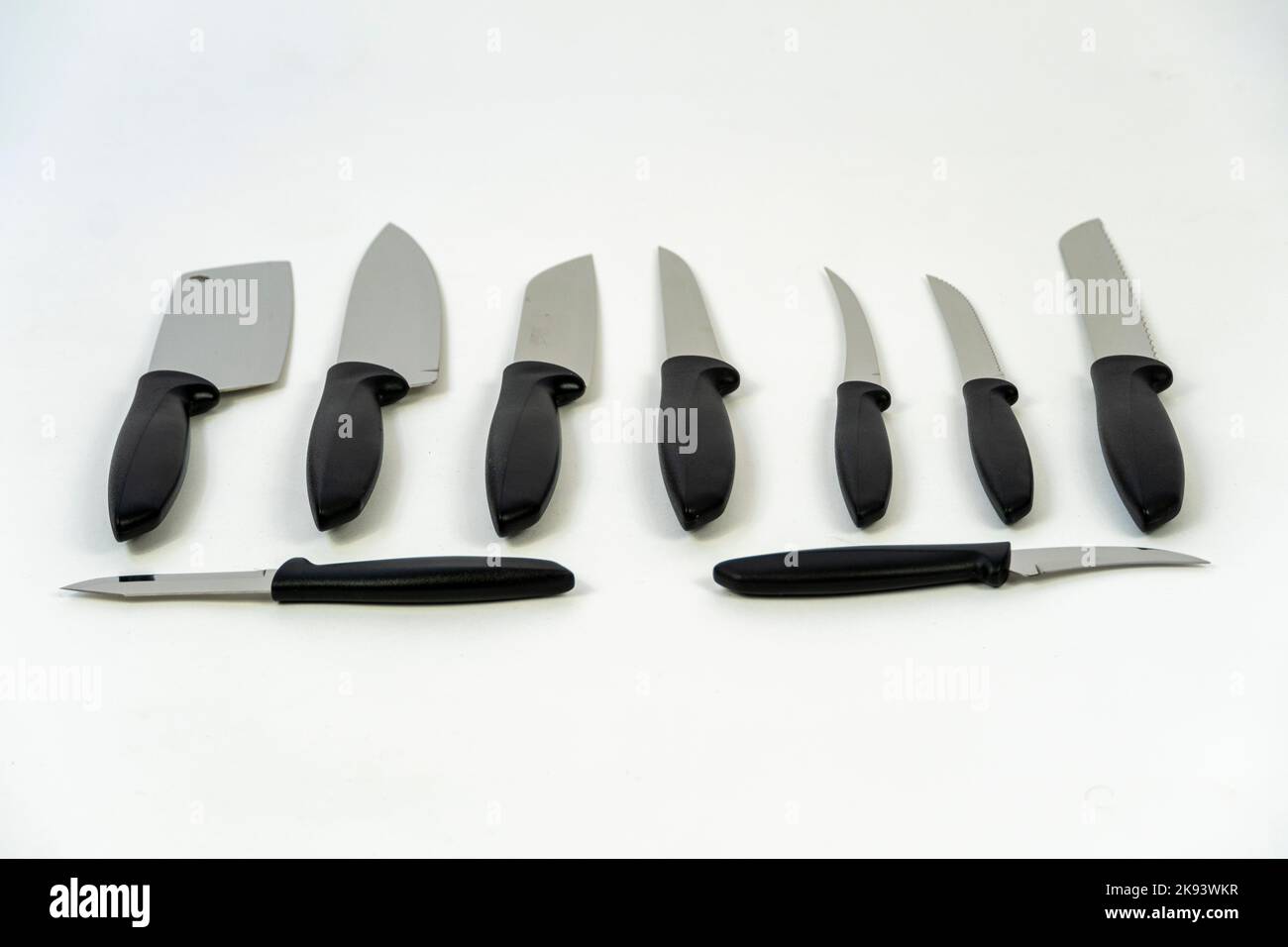 Cuchillo de cocina grande afilado sobre una superficie oscura, fondo blanco méxico Foto de stock