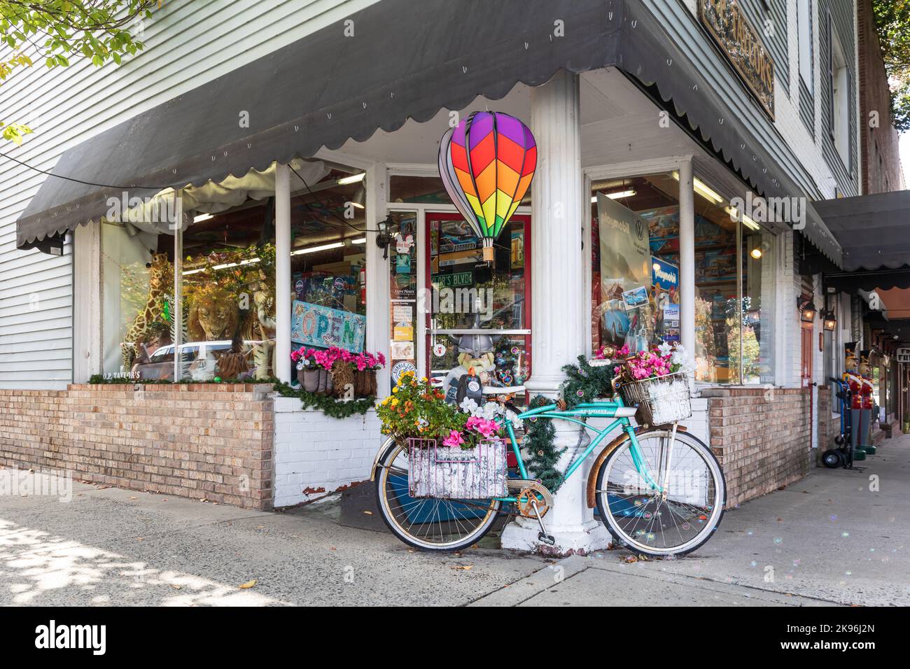 BREVARD, CAROLINA DEL NORTE, EE.UU.-9 OCTUBRE 2022: Tienda de juguetes de O. P. Taylor, mostrando la entrada exterior de la esquina con una bicicleta cubierta de flores en exhibición. Foto de stock