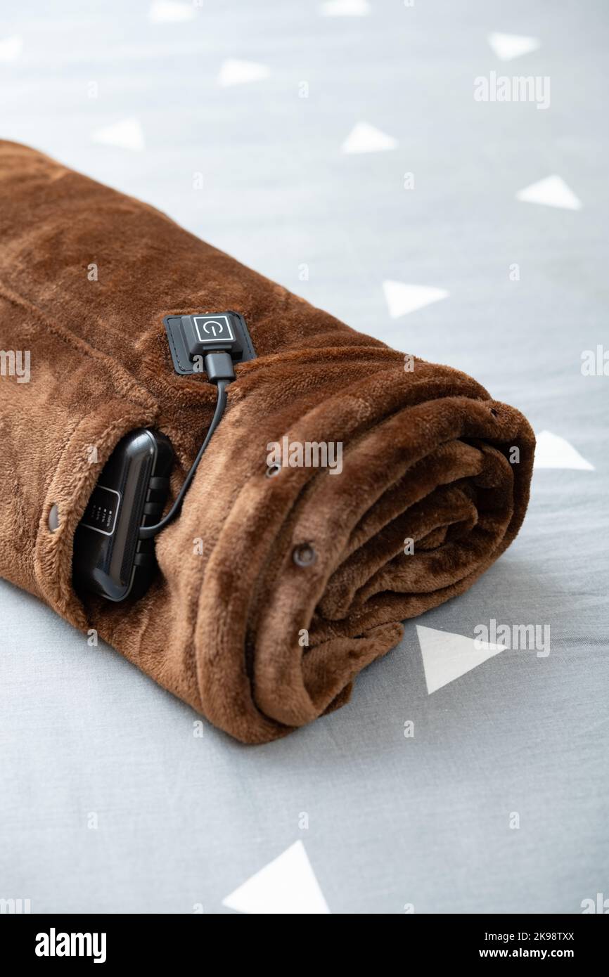 de visión rodada manta eléctrica con cargador portátil como fuente de en una cama de vertical Fotografía de stock - Alamy