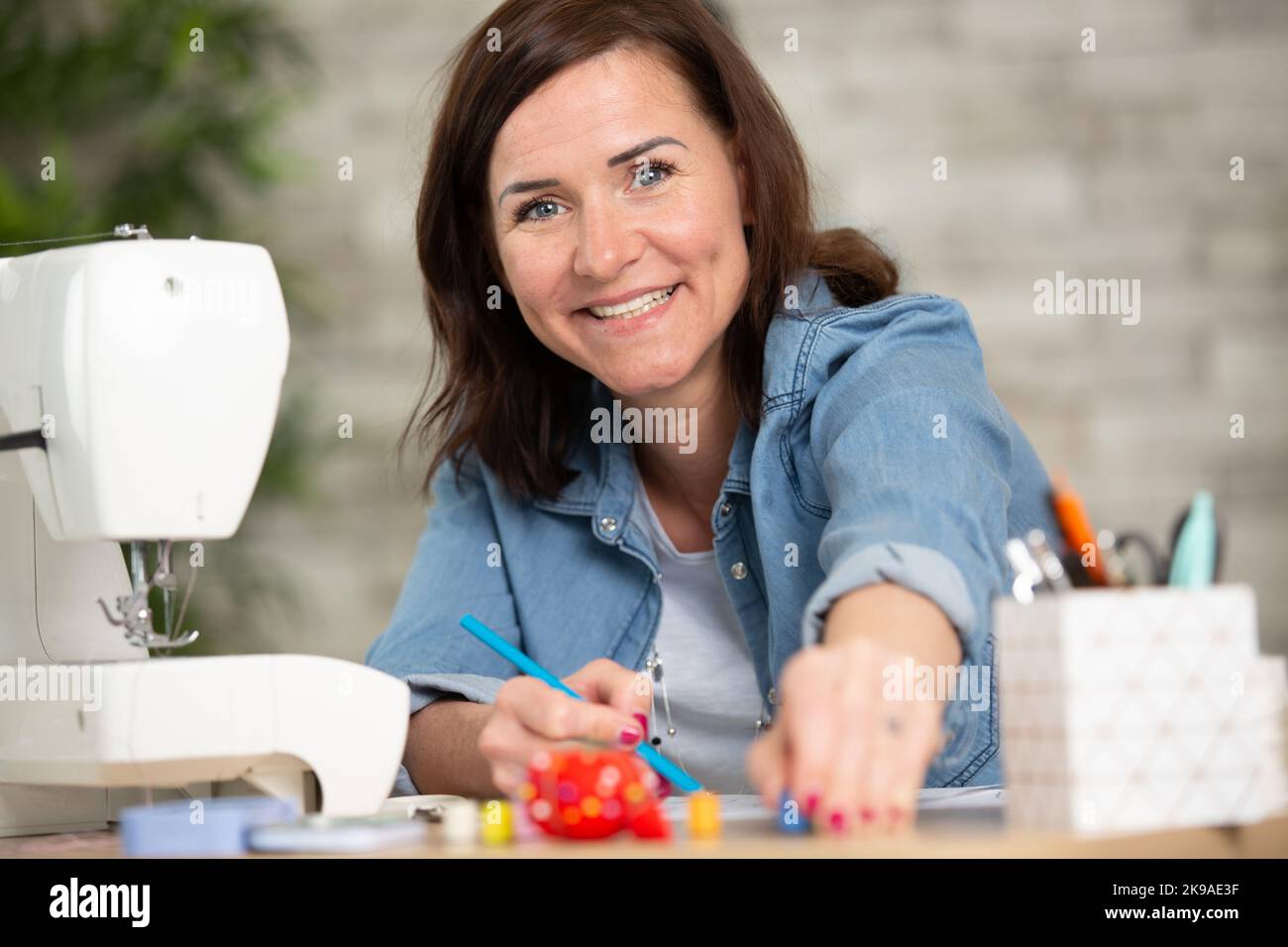 retrato de alegre fabricante de ropa se sentó en su escritorio Foto de stock