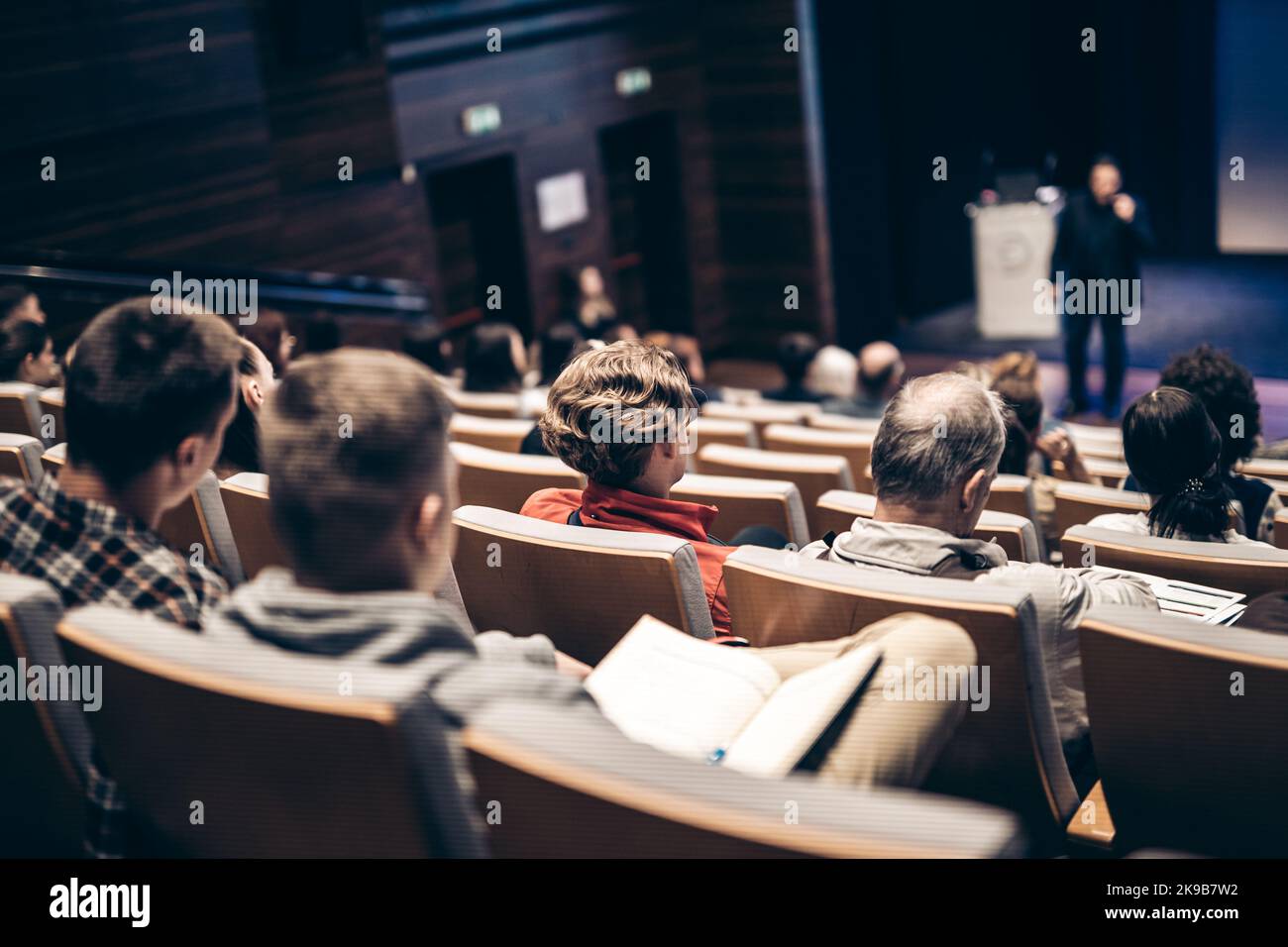 Orador dando una charla en la sala de conferencias en un evento de negocios. Vista posterior de personas irreconocibles en la sala de conferencias. Negocios y. Foto de stock