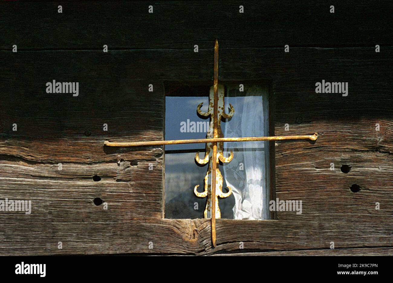 Homita, Condado de Gorj, Rumania, 2000. Vista exterior de la iglesia de madera del siglo 18th, monumento histórico. Primer plano de una ventana muy pequeña con barras de metal. Foto de stock