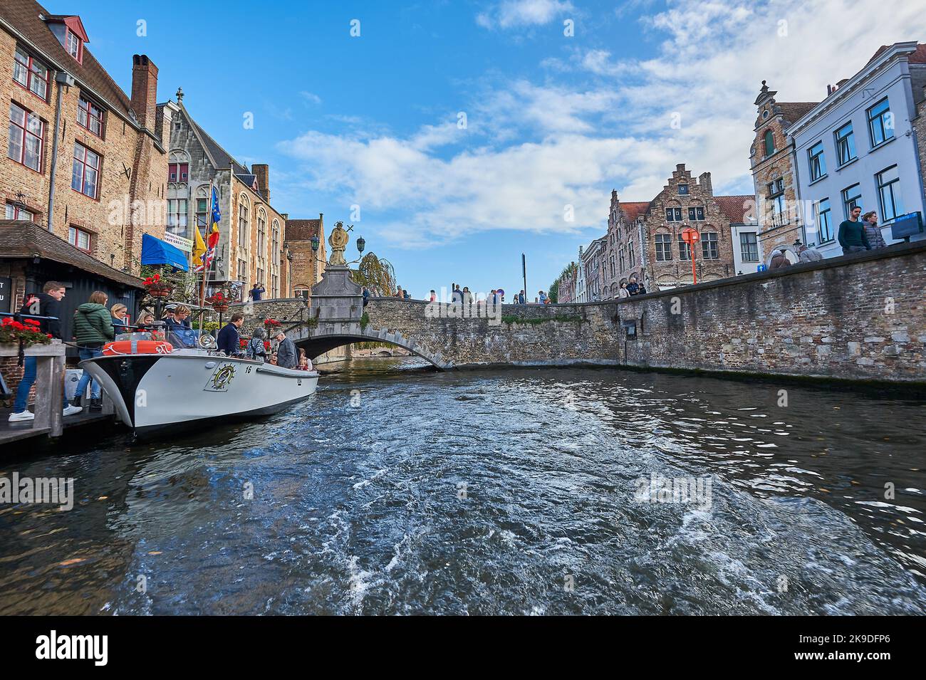 Brujas (Brujas) en Flandes, Bélgica y barcos turísticos operan en el canal Groenerei en el corazón de la ciudad histórica. Foto de stock