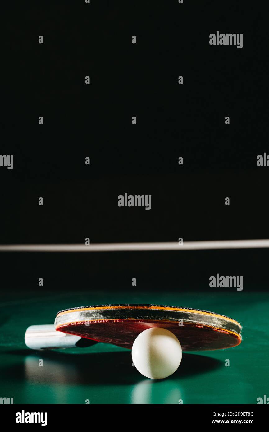 Raqueta de ping pong apoyada en una pelota de ping pong Foto de stock