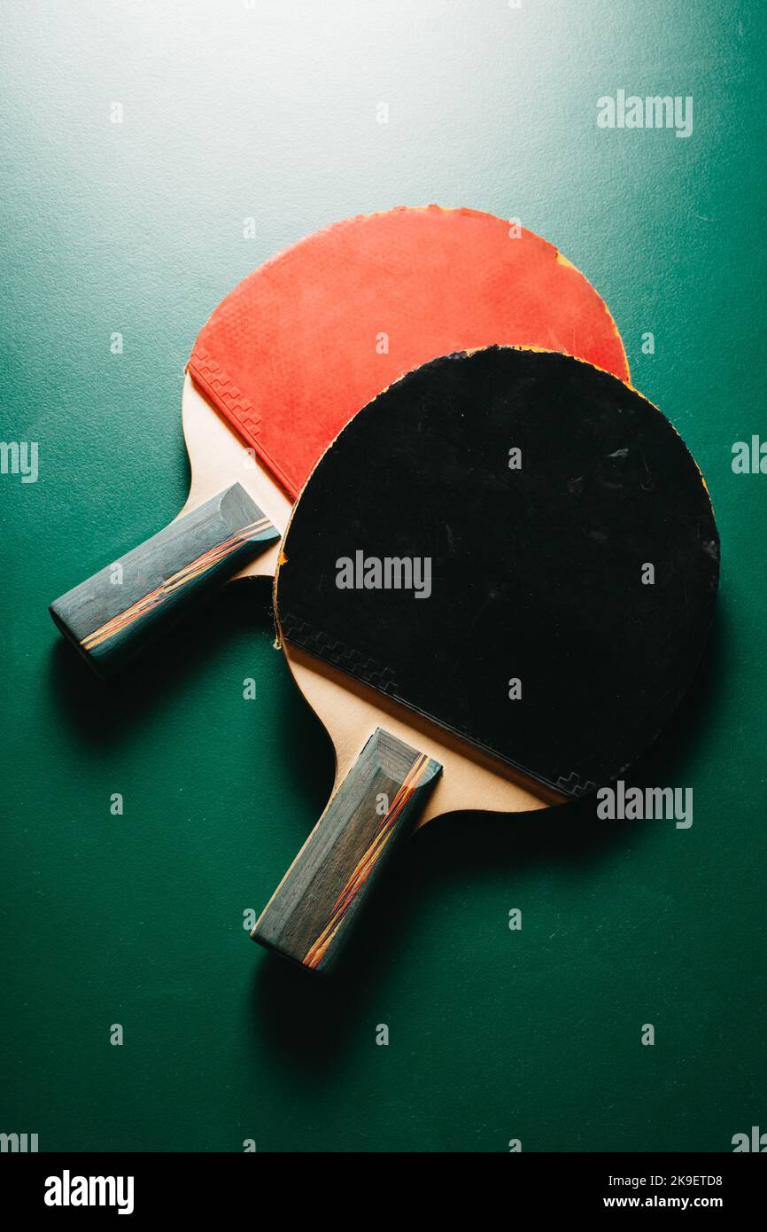 Hay dos raquetas de ping pong en la mesa de juegos verde Foto de stock