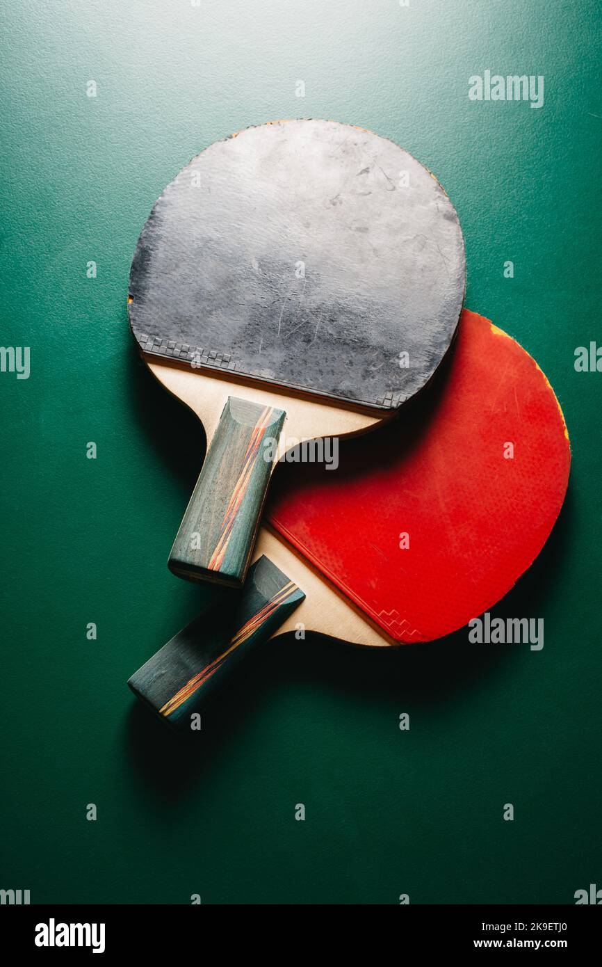 Hay dos raquetas de ping pong en la mesa de juegos verde Foto de stock