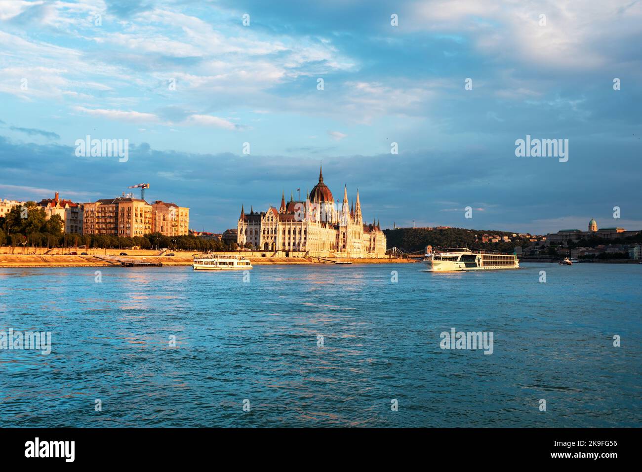Edificio del Parlamento húngaro a lo largo del río Danubio al amanecer con colorido nubes cielo Foto de stock