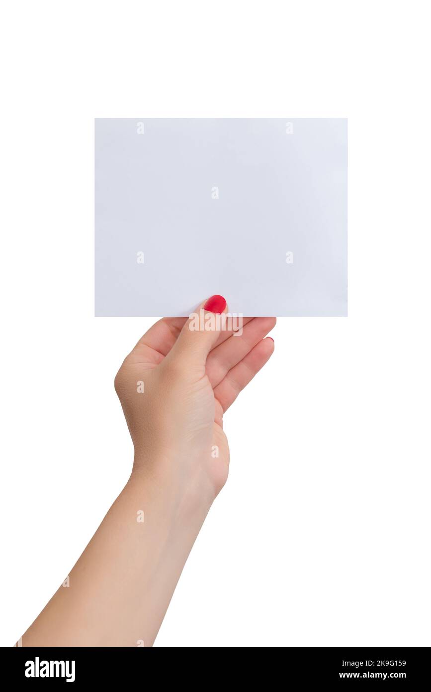 La mano de la mujer sostiene una pequeña hoja de papel en blanco. Fondo aislado. Maqueta de papel para la presentación de texto Foto de stock