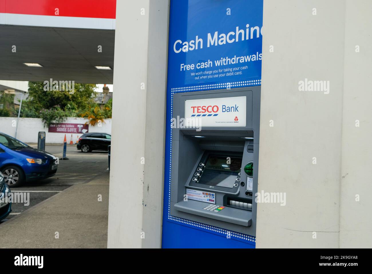 Londres- Octubre 2022: Cajero automático Tesco Bank en una gasolinera Tesco Esso en Wimbledon, al suroeste de Londres Foto de stock