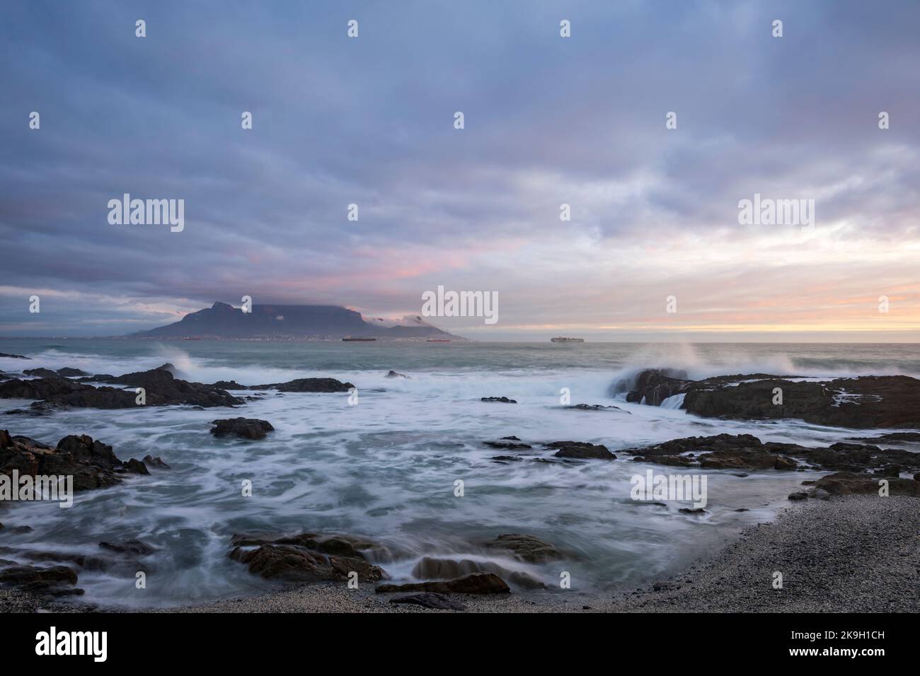 Vista emblemática de la bahía de Table en Table Mountain y Ciudad del Cabo en un día nublado al atardecer desde Bloubergstrand en Western Cape. Sudáfrica. Foto de stock