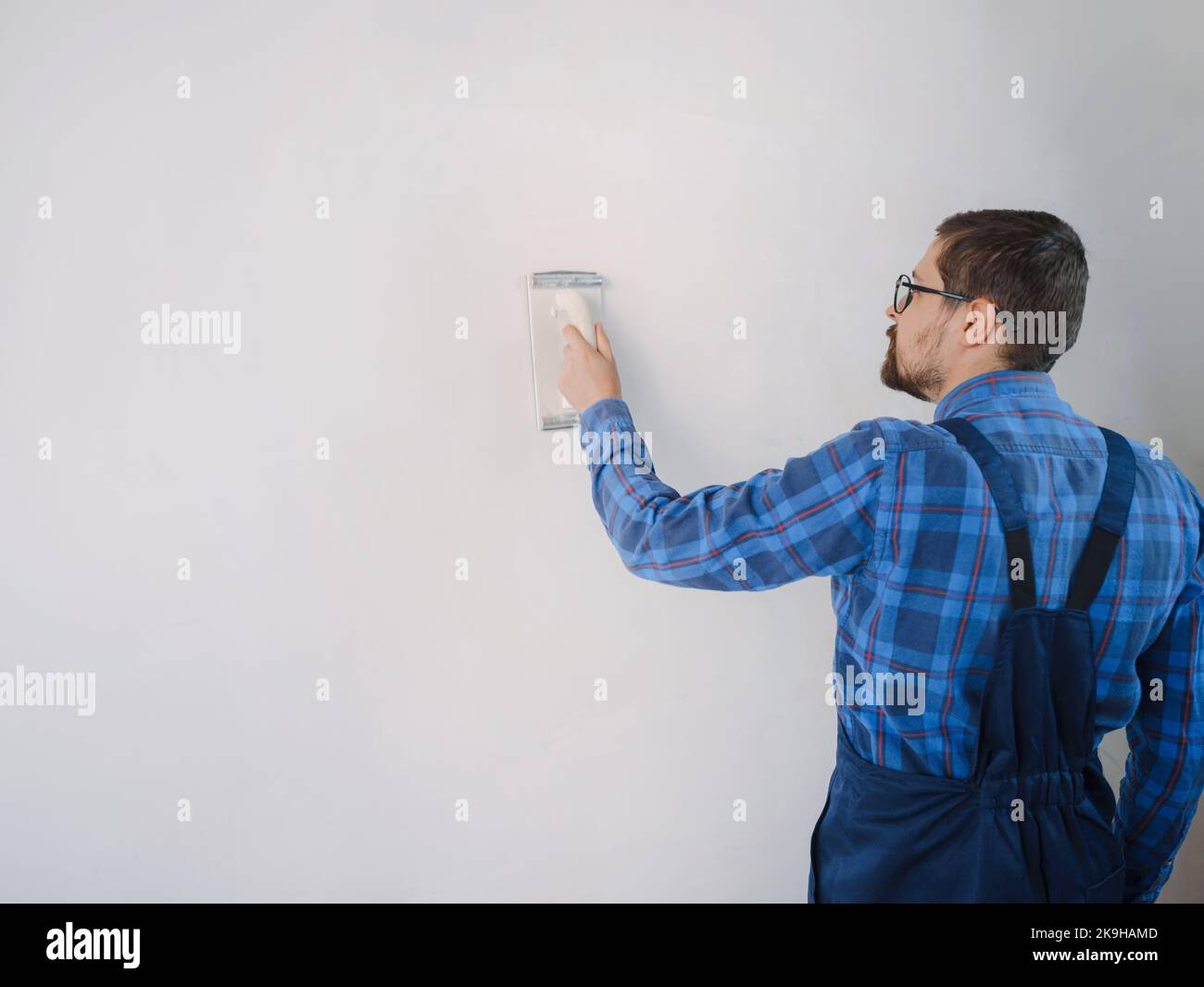 Use papel de lija para lijar la superficie de la pared. nivelación