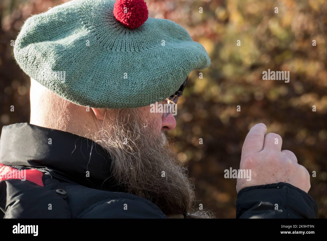 Mann mit langem Bart und Schottenmütze fotografiert mit seinem Handy Foto de stock