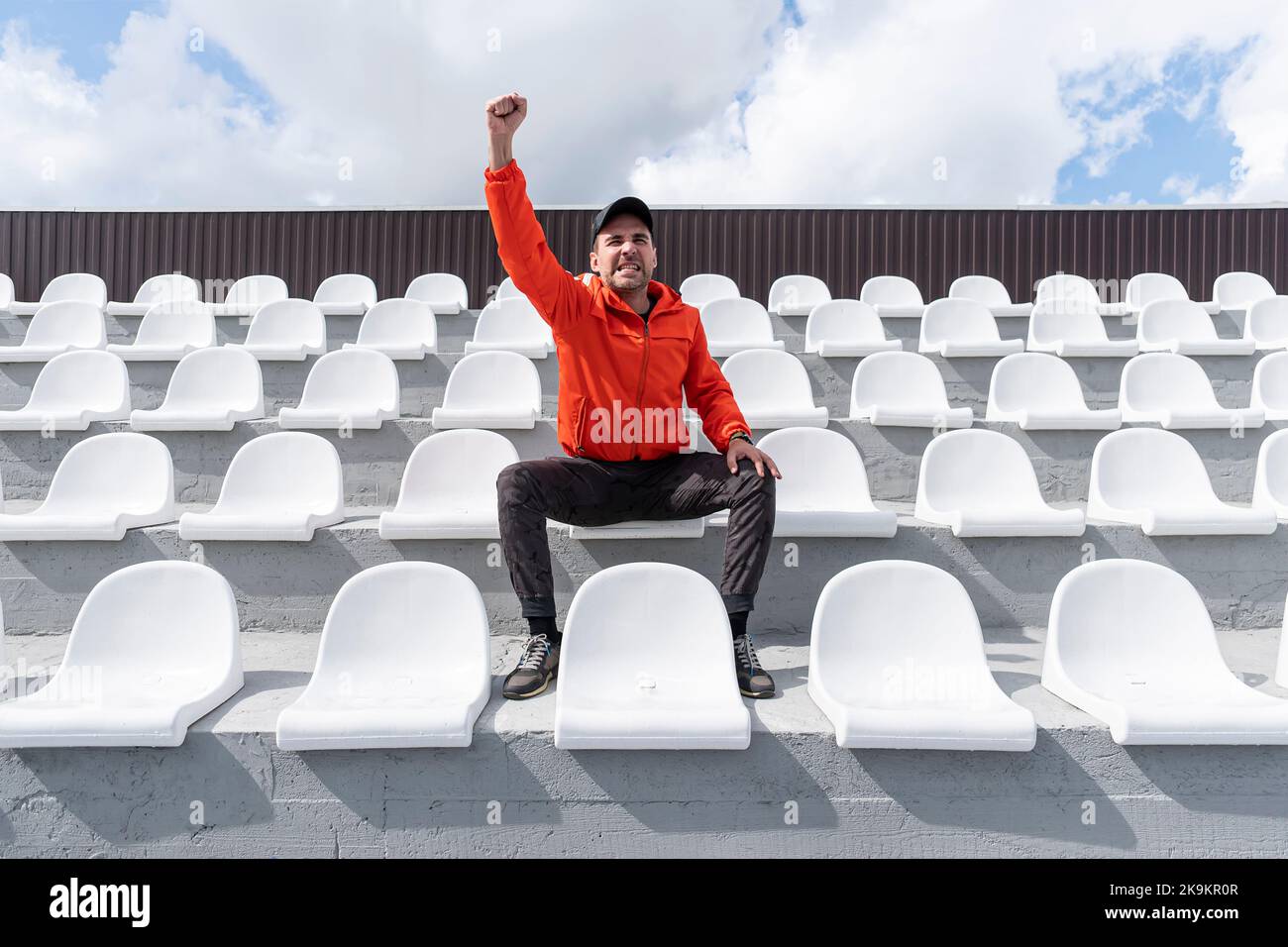 sólo hay una persona sentada en la tribuna. Se sienta sin una máscara y mira delante de él. Cuarentena. Foto de stock