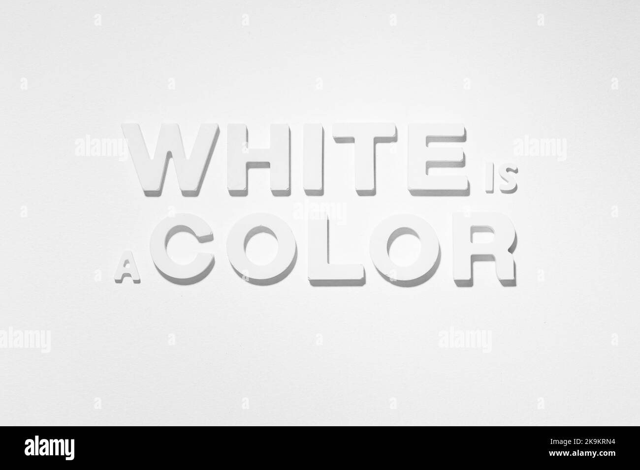 El blanco es una frase de color por letras moldeadas sobre fondo blanco. Fotografía en blanco y negro Foto de stock
