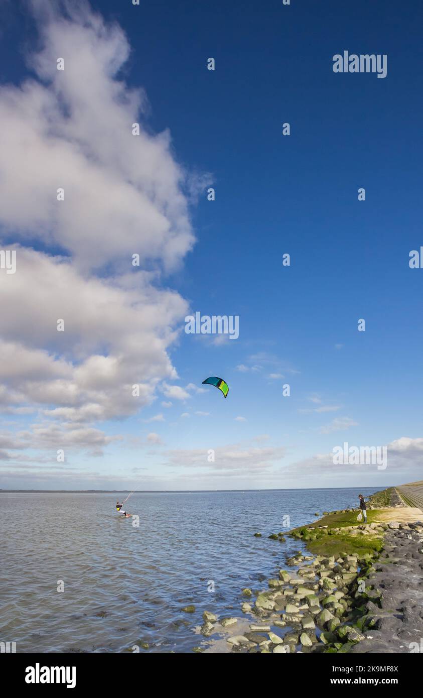 Kitesurfer a lo largo del dique del mar de Wadden en Friesland, Holanda Foto de stock