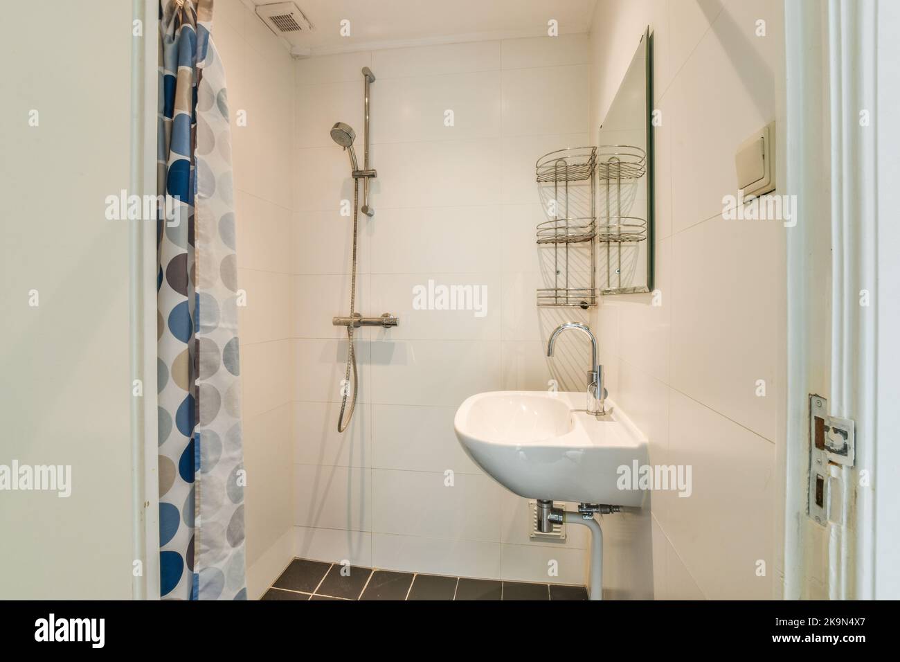 Grifos de ducha pegados a la pared de azulejos cerca de la ventana del baño  en casa