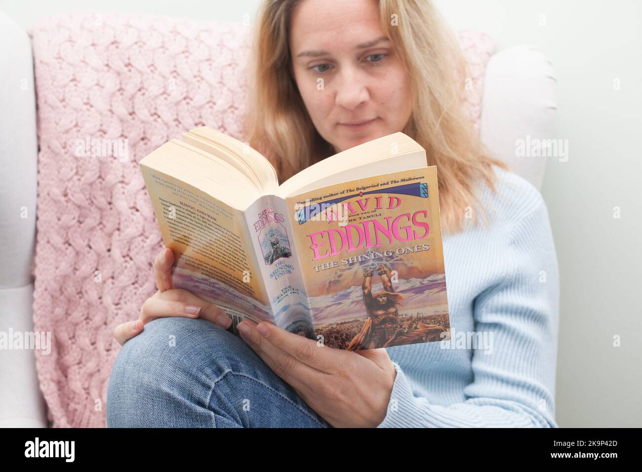 Una mujer leyendo el libro Los Luminosos de David Eddings Foto de stock