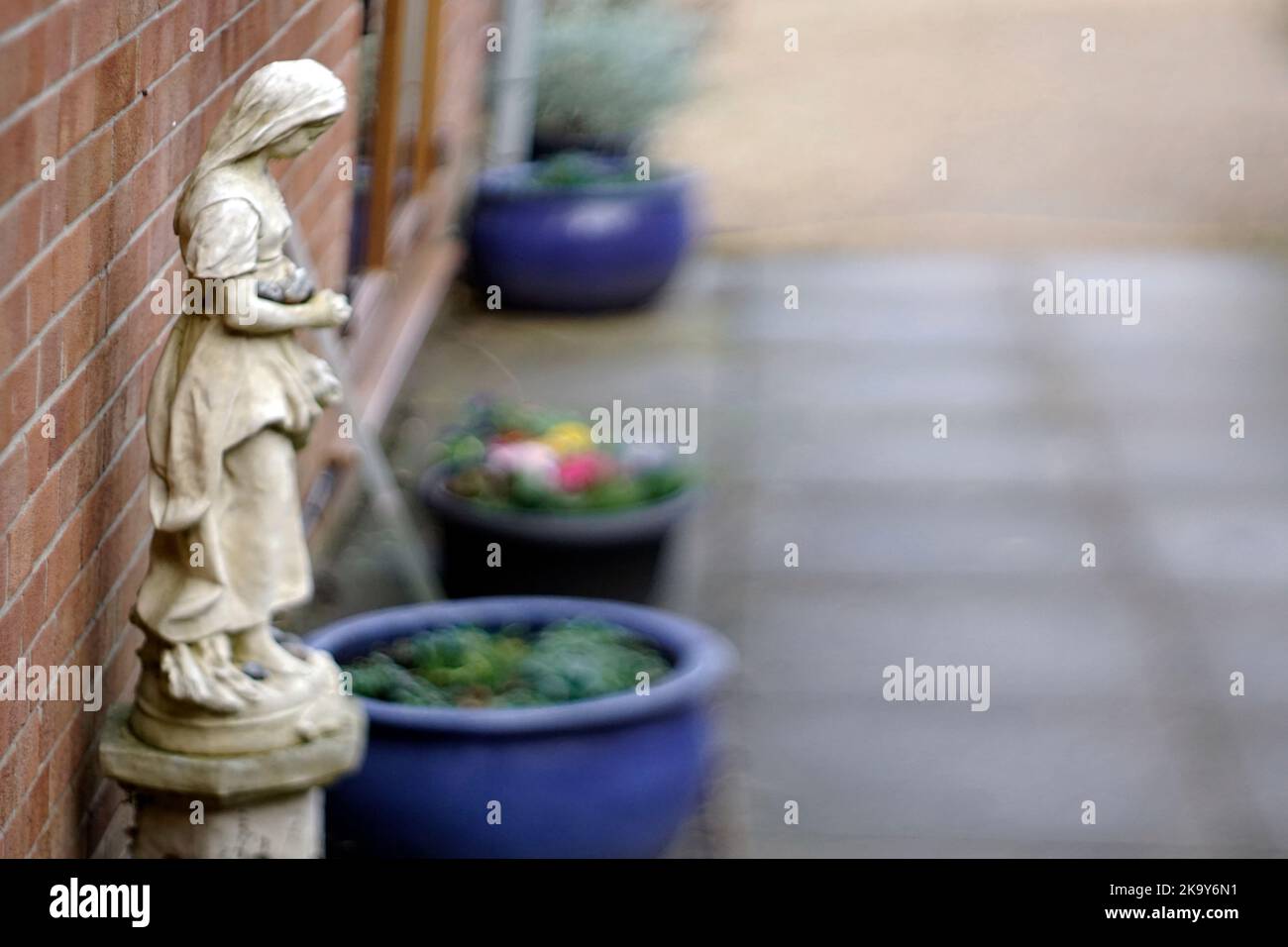 pequeña estatua de mujer penitente en el jardín Foto de stock