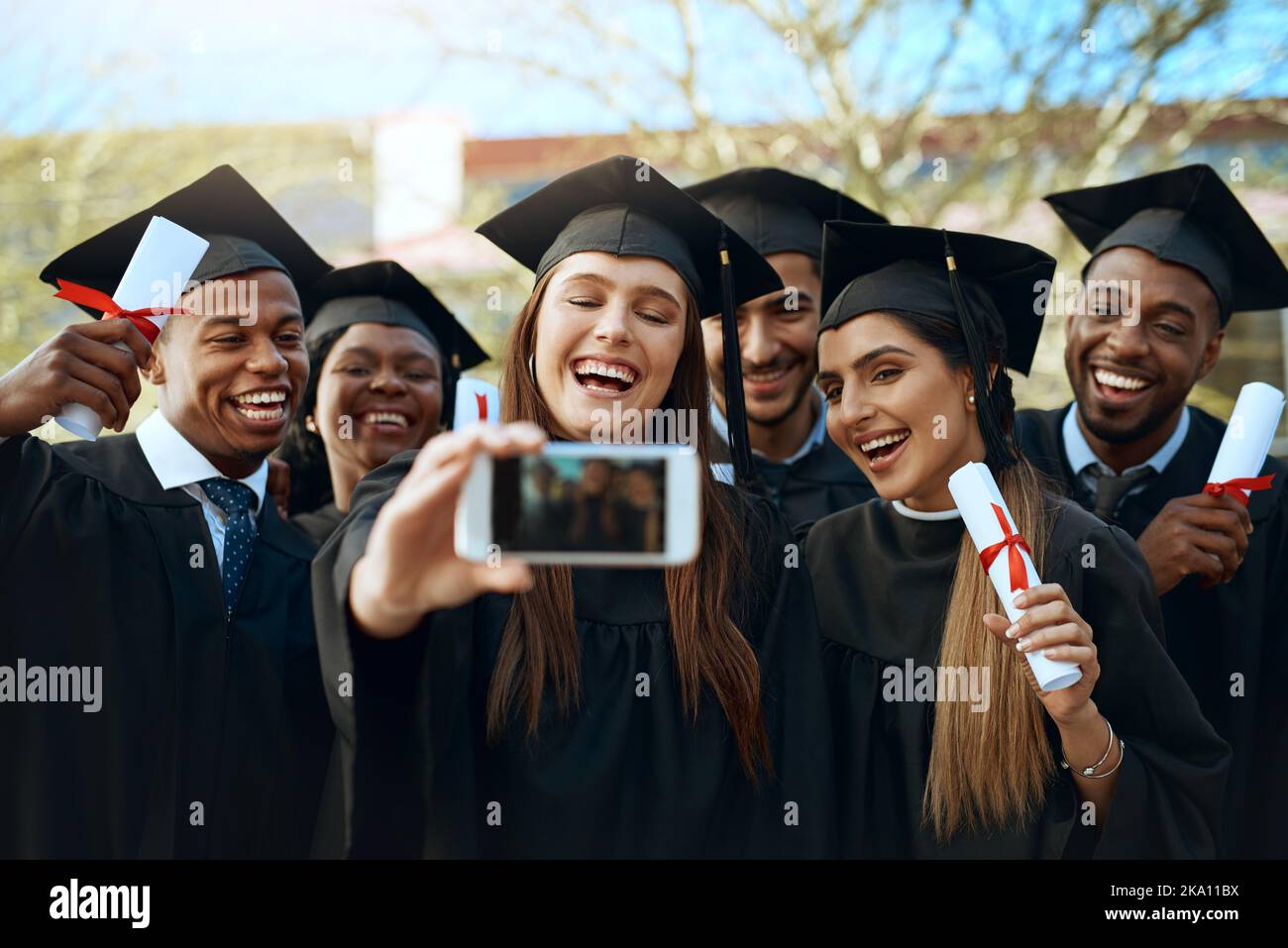 Algunas de las mejores amistades se forman en la universidad. Un grupo de  estudiantes tomando selfies con un teléfono móvil el día de la graduación  Fotografía de stock - Alamy