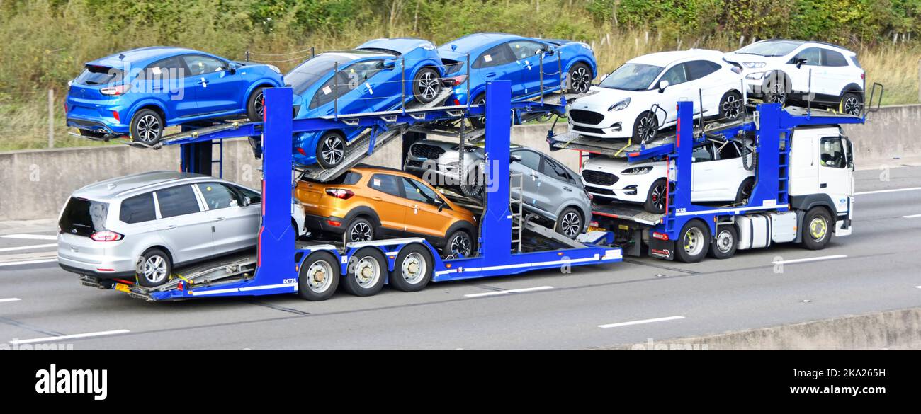 Ford compañía de motor camión camioneta transportista de entrega y remolque cargado con nueve nuevos coches no registrados que conducen a lo largo de la carretera de autopista del Reino Unido Essex Inglaterra Foto de stock