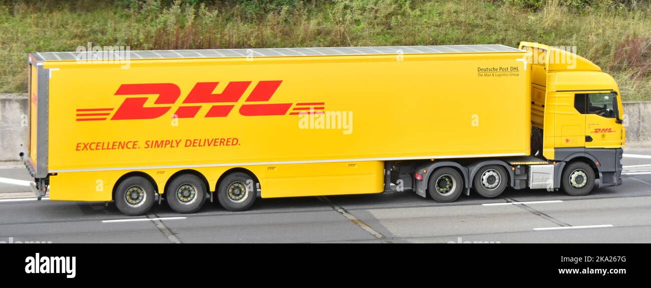 Vista lateral DHL HOMBRE camión marca & trailer un paquete de mensajería internacional entrega correo express logística cadena de suministro de negocio de la autopista reino unido carretera Foto de stock