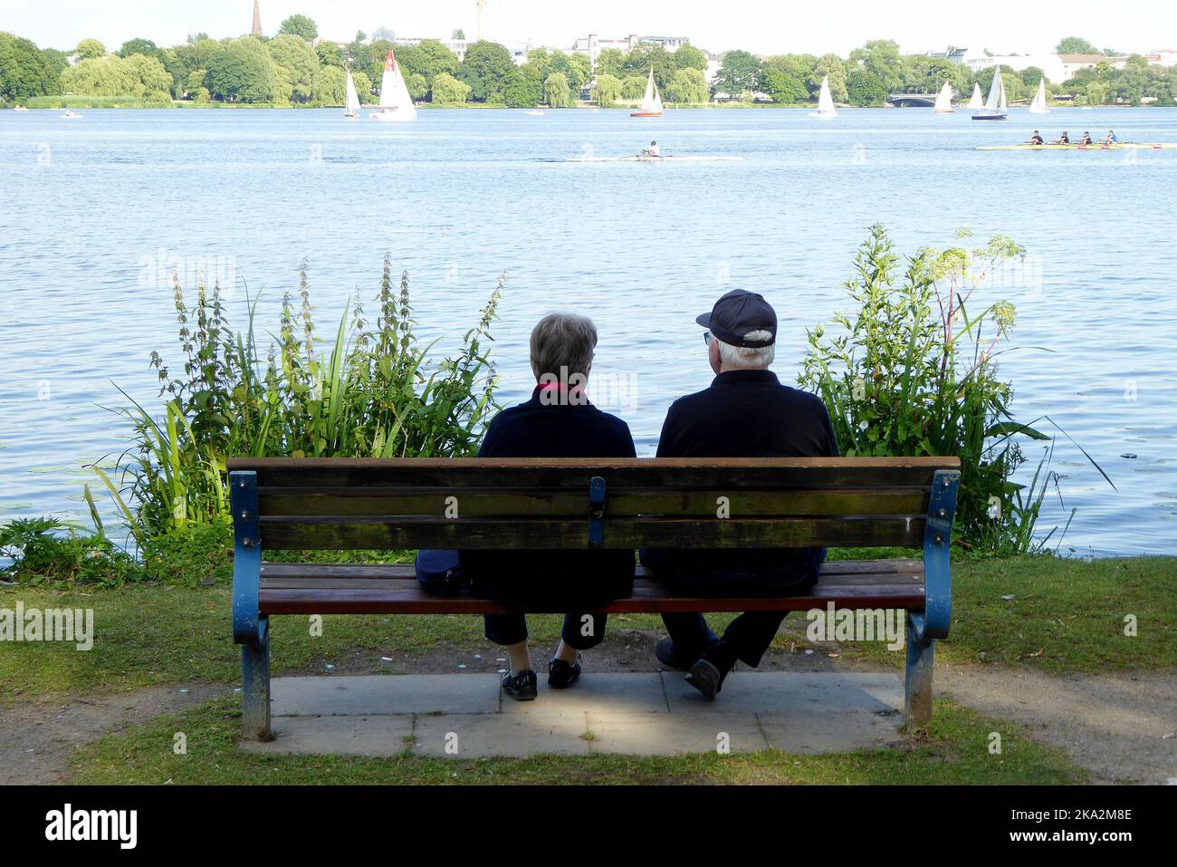 Ein Paar auf der Parkbank an der Aussen Alster en Hamburgo. Foto de stock
