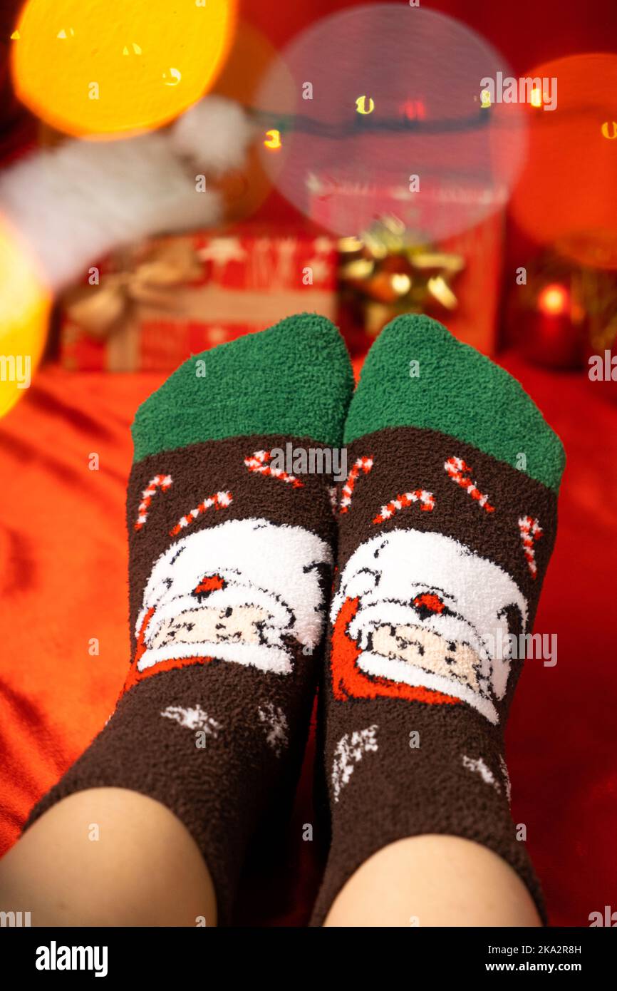Pies de mujer en cálidos calcetines navideños con un primer plano de Santa  Claus Fotografía de stock - Alamy