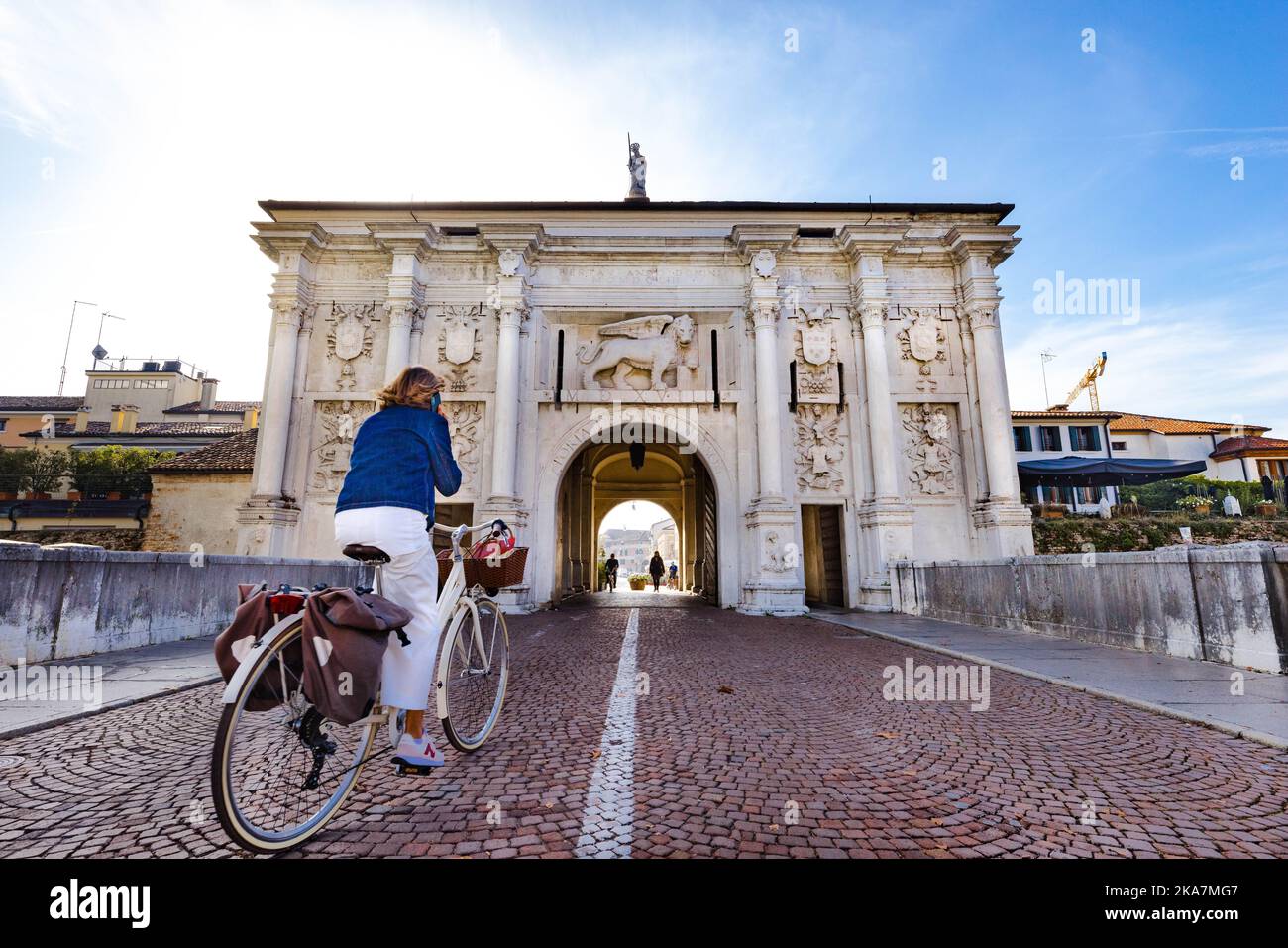 Treviso - la porta di San Tomaso con turista in bicicletta in movimento - trasporto evologico green - Veneto,Italia Foto de stock