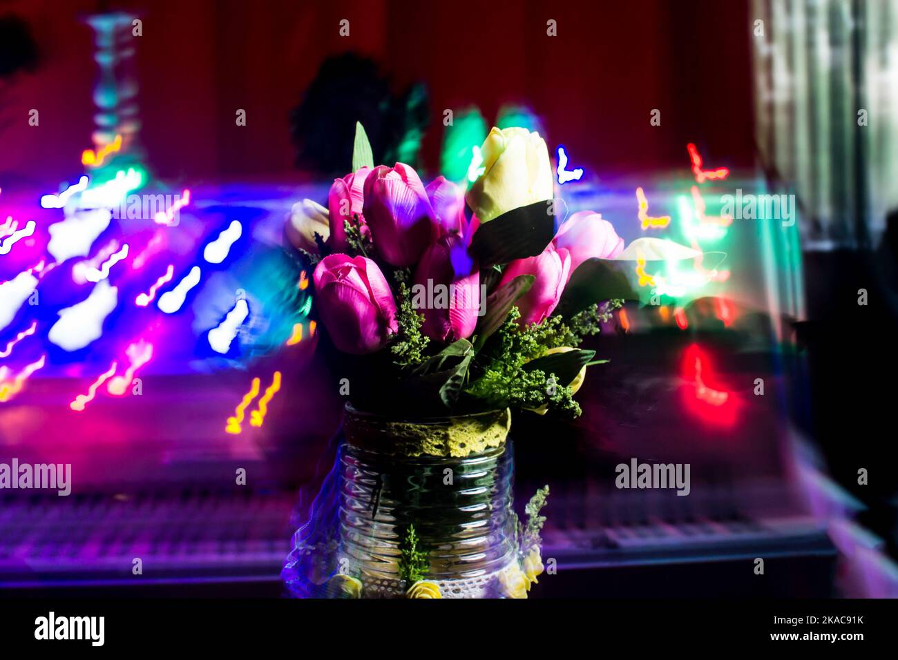 Jarrón de cristal azul con flores de tulipán sobre un bouquet de flores veraniegas sobre un fondo artísticamente borroso con bokeh.Verano todavía l Foto de stock
