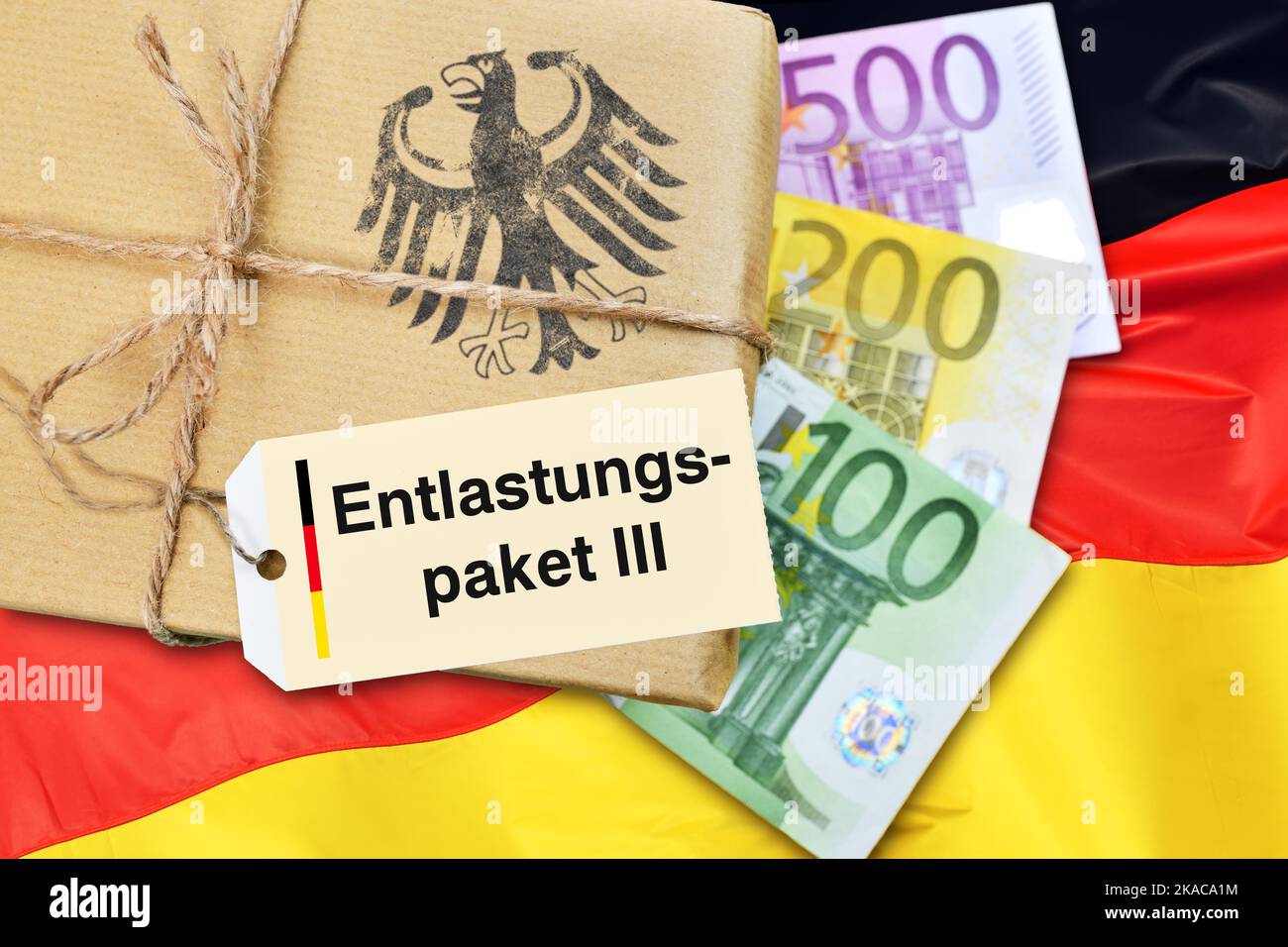 FOTOMONTAGE, Paket mit Etikett und Aufschrift Entlastungspaket III mit Geldscheinen und Deutschlandfahne Foto de stock