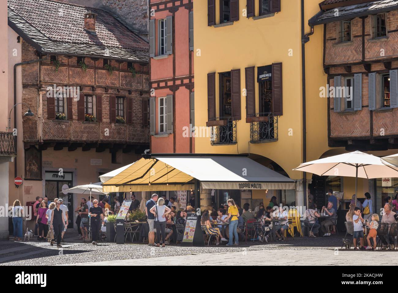 Piazza San Fedele Como, vista en verano de las personas sentadas en las mesas en la histórica Piazza San Fedele en la ciudad de Como, Lago Como, Lombardía Foto de stock