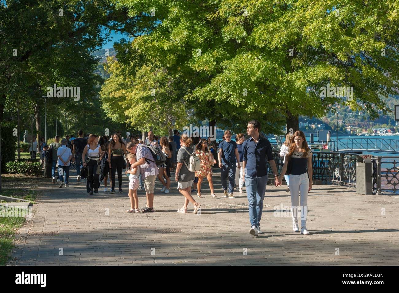 La gente que camina parque, vista en verano de la gente que camina en el camino del lago en el Giardini del Tempiano Voltiano en la ciudad de Como, Lago Como, Italia Foto de stock