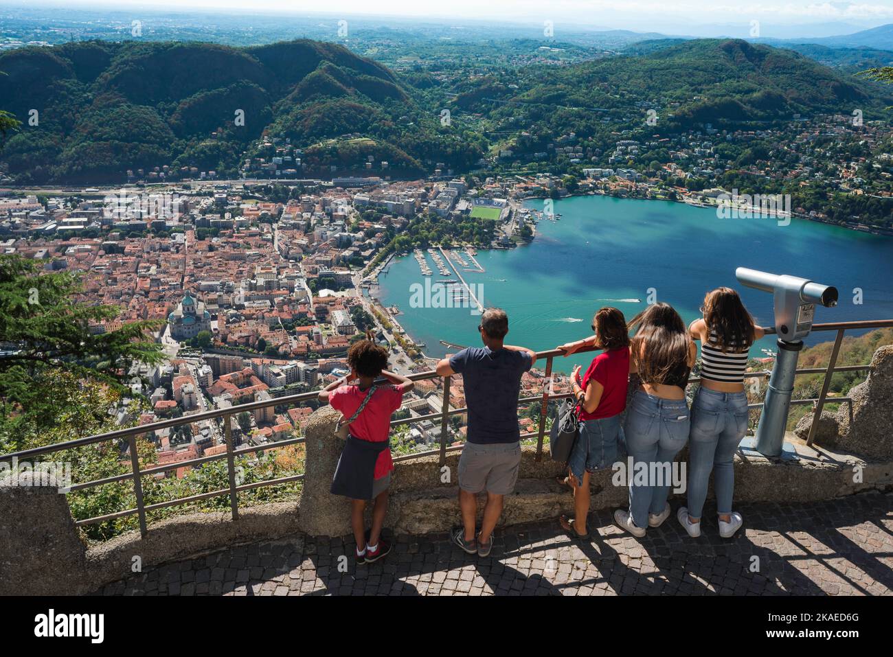 Vacaciones familiares en Europa, vista en verano de un grupo familiar mirando hacia abajo en la pintoresca ciudad de Como desde el punto de vista de Brunate, Lago Como, Lombardía, Italia Foto de stock