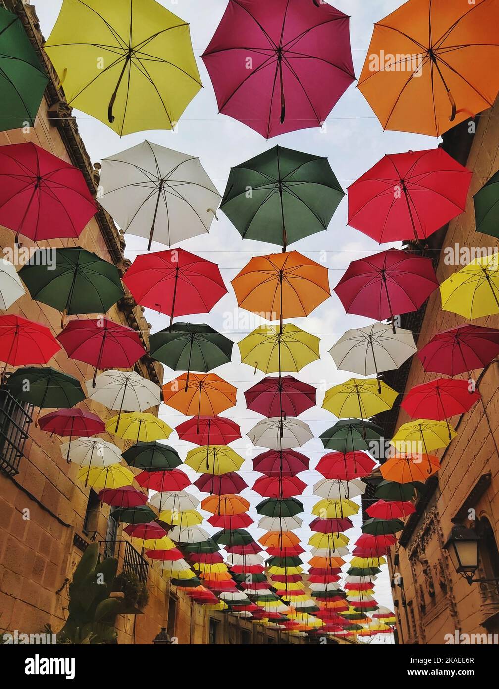 Las coloridas sombrillas cuelgan de una calle típica del centro de Barcelona  Fotografía de stock - Alamy