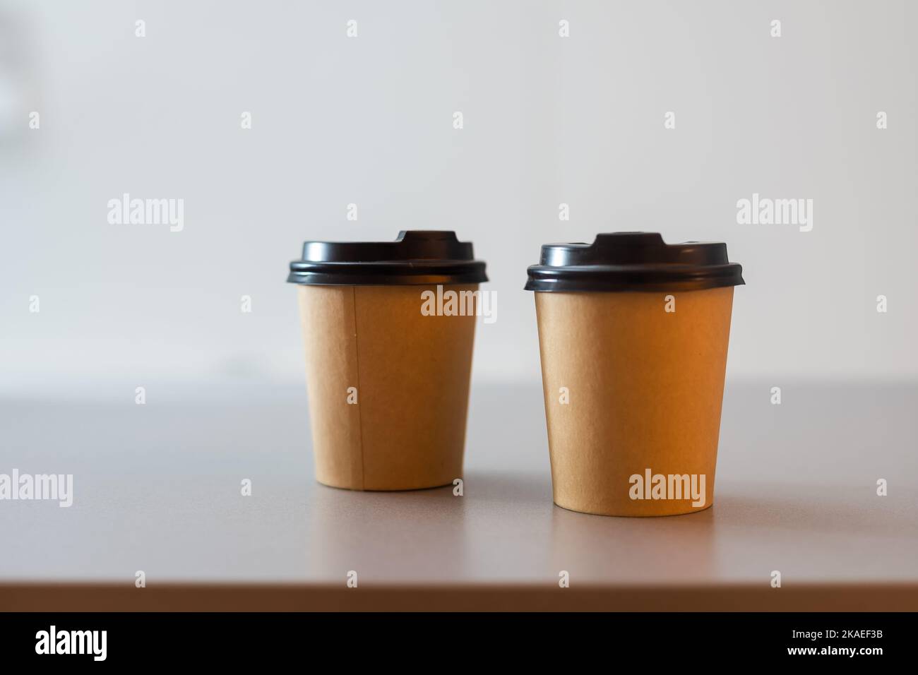 Dos tazas de café de papel sobre una mesa Foto de stock